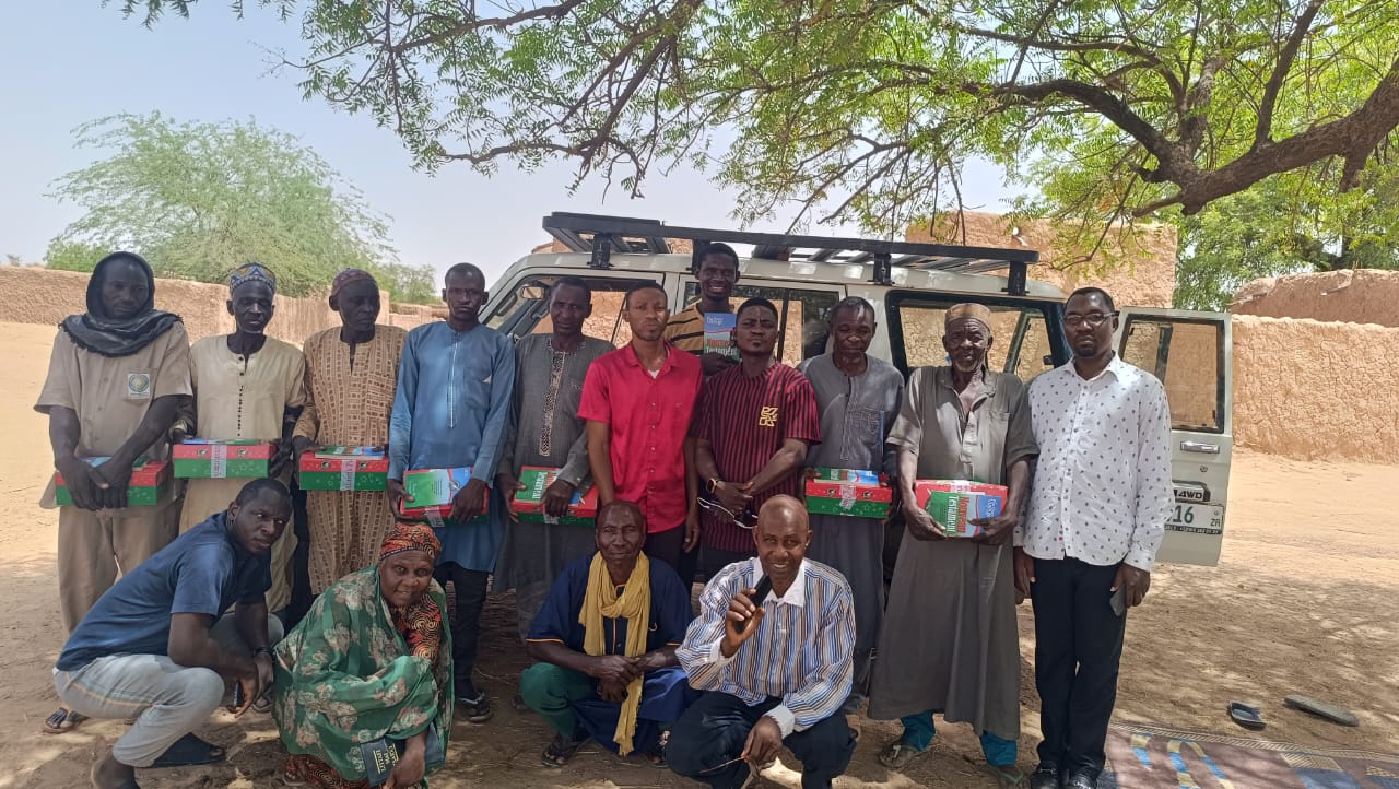 Mission team and villagers gathered by a vehicle during the Grace Church Keighley mission in Niger
